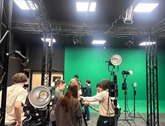 plateau de tournage avec des étudiants en audiovisuel, fond vert et installation complète avec du matériel professionnel